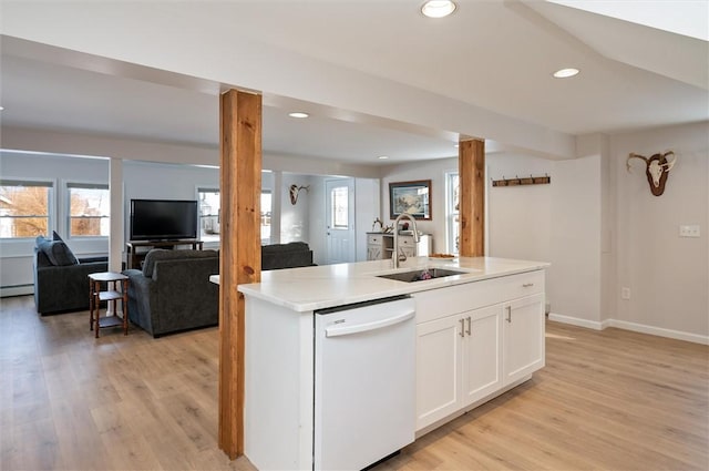 kitchen with white cabinetry, dishwasher, sink, light hardwood / wood-style floors, and a center island with sink