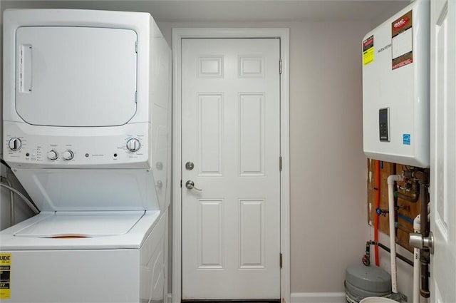 clothes washing area with tankless water heater and stacked washer and clothes dryer