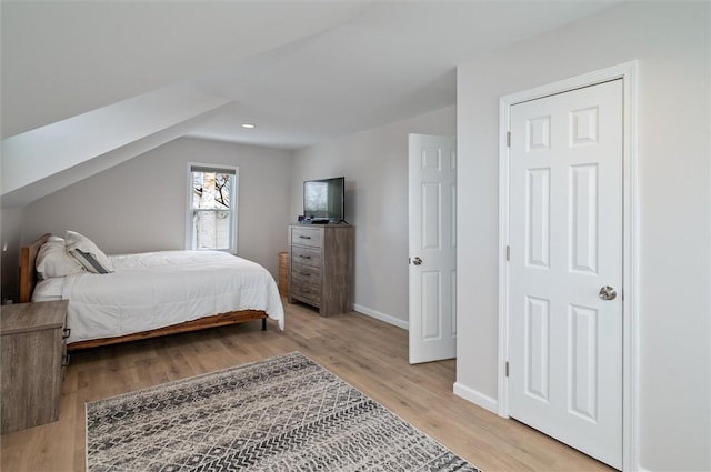 bedroom featuring vaulted ceiling and light hardwood / wood-style flooring