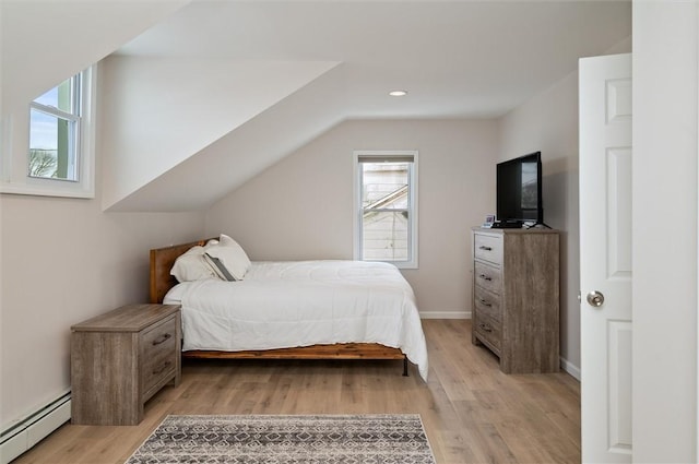 bedroom featuring multiple windows, light wood-type flooring, and baseboard heating