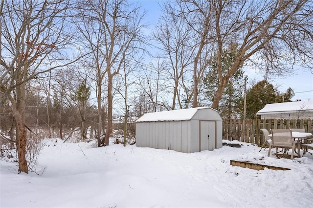 yard layered in snow featuring a shed