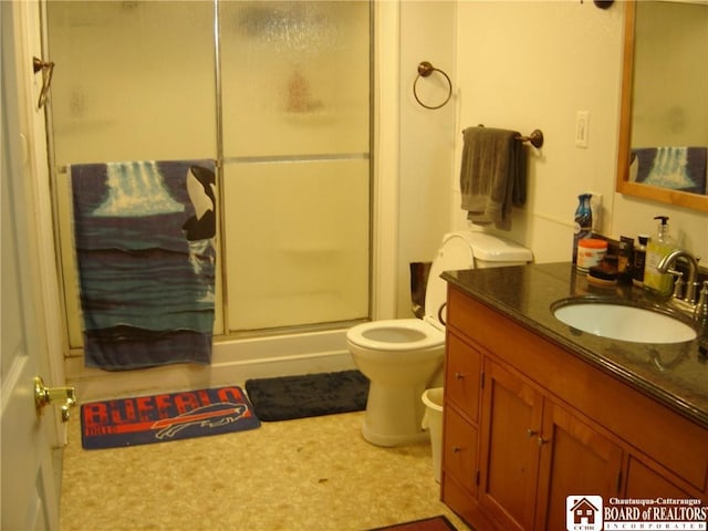 bathroom with vanity, toilet, and a shower with shower door