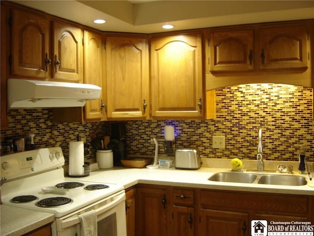 kitchen with under cabinet range hood, a sink, light countertops, and white electric range oven