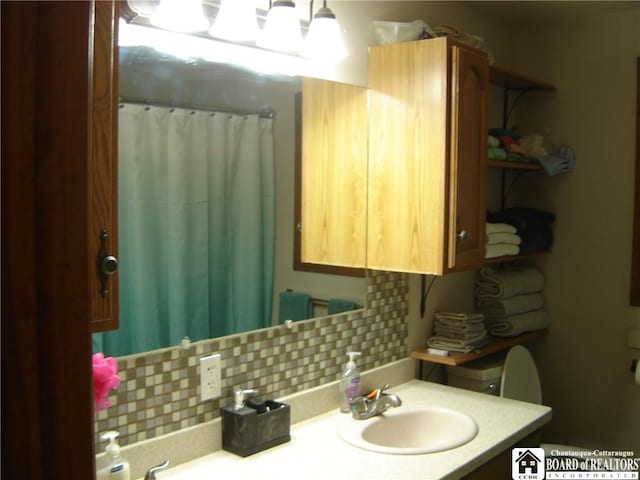 bathroom with tasteful backsplash, toilet, vanity, and a shower with shower curtain