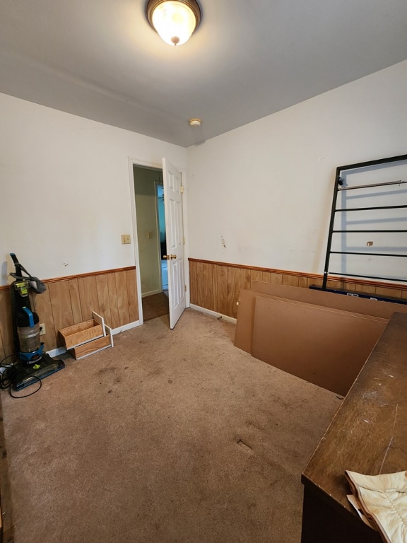 bedroom featuring carpet flooring and wood walls