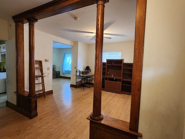 hall featuring decorative columns and light hardwood / wood-style flooring