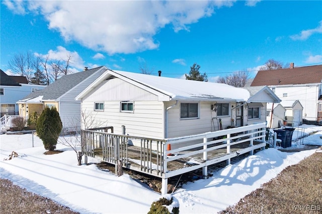 snow covered property with a deck