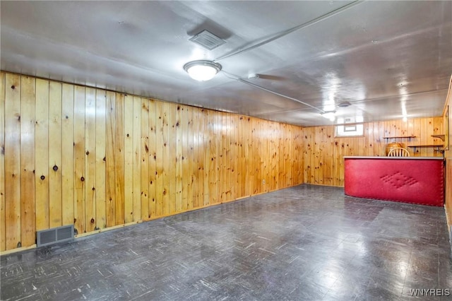 basement featuring wooden walls