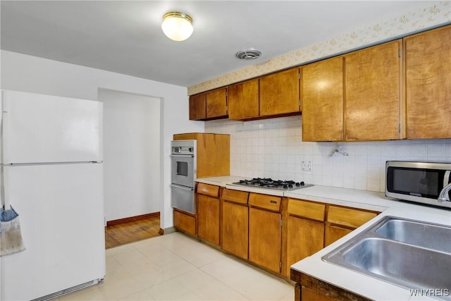 kitchen featuring stainless steel appliances, sink, and backsplash