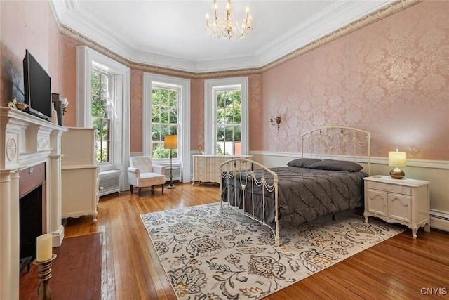 bedroom featuring an inviting chandelier, hardwood / wood-style floors, and ornamental molding