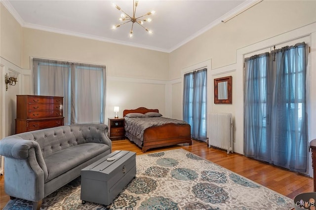 bedroom with a chandelier, ornamental molding, radiator, and hardwood / wood-style floors