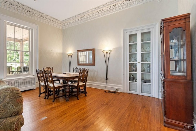 dining area with radiator and light hardwood / wood-style flooring