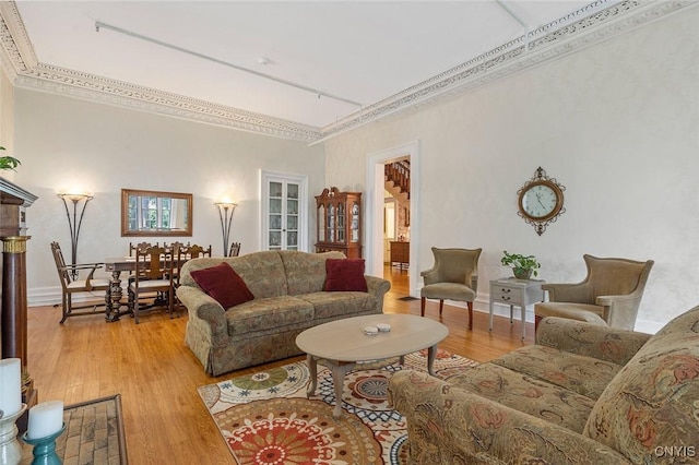 living room with crown molding and light hardwood / wood-style flooring