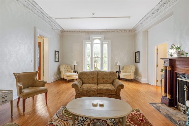 living room with hardwood / wood-style flooring, a high end fireplace, and crown molding