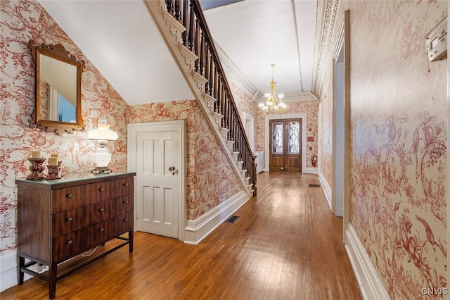 foyer with an inviting chandelier, hardwood / wood-style flooring, and french doors