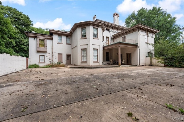 rear view of house featuring a balcony and a patio area