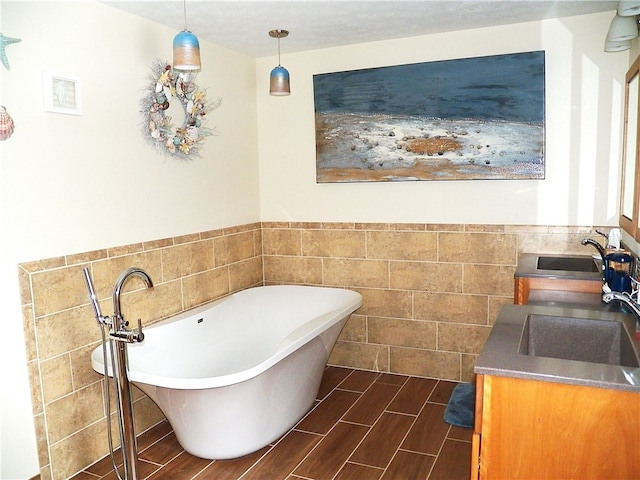 bathroom with vanity, a bathing tub, and tile walls