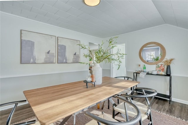 dining room featuring crown molding, vaulted ceiling, and hardwood / wood-style floors