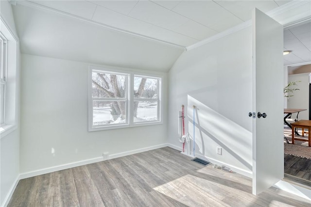 spare room with lofted ceiling and light hardwood / wood-style floors