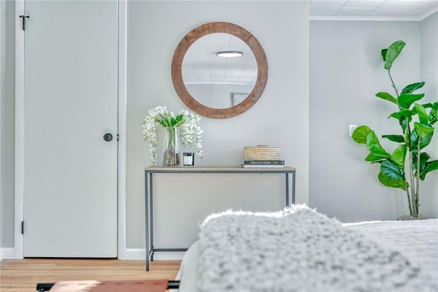 bedroom with ornamental molding and hardwood / wood-style floors