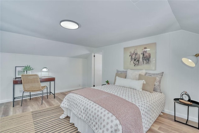 bedroom with lofted ceiling and light hardwood / wood-style flooring