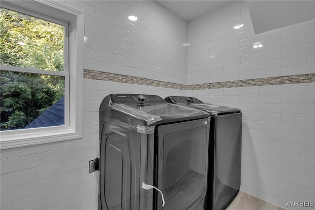 clothes washing area featuring washer and dryer and light wood-type flooring