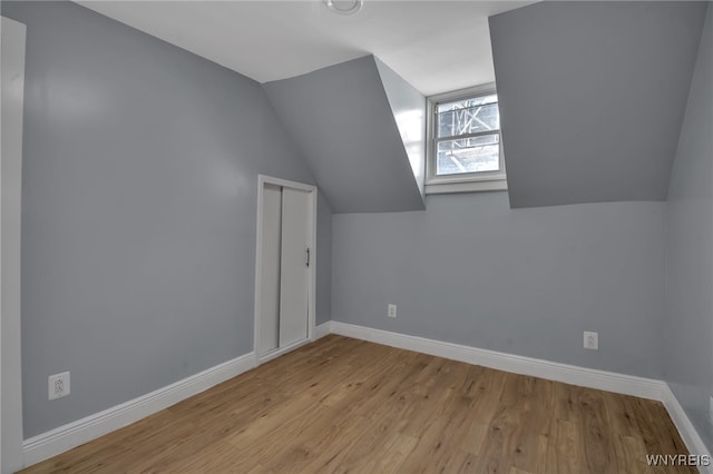 additional living space featuring lofted ceiling and light hardwood / wood-style flooring