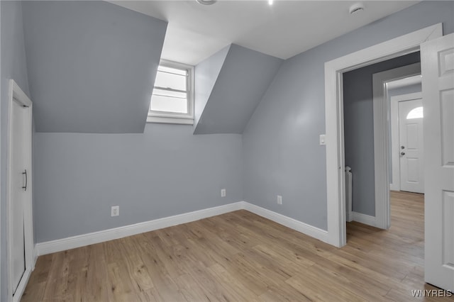 additional living space featuring light hardwood / wood-style flooring and vaulted ceiling