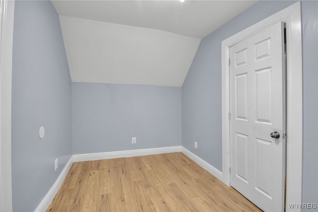 additional living space featuring lofted ceiling and light hardwood / wood-style flooring