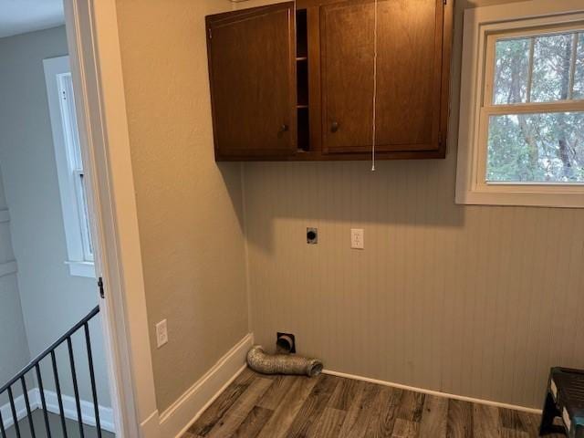 washroom with baseboards, hookup for an electric dryer, dark wood finished floors, attic access, and cabinet space