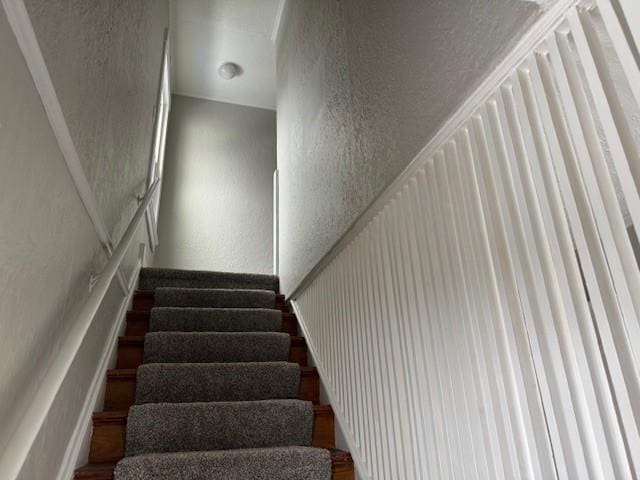 staircase with a textured wall