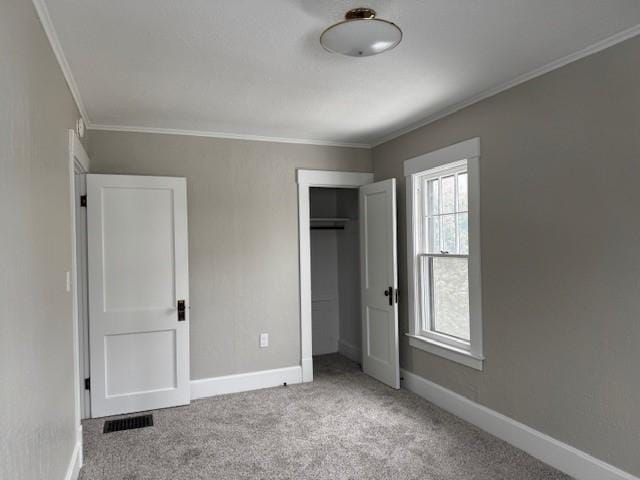 unfurnished bedroom featuring carpet floors, baseboards, and ornamental molding