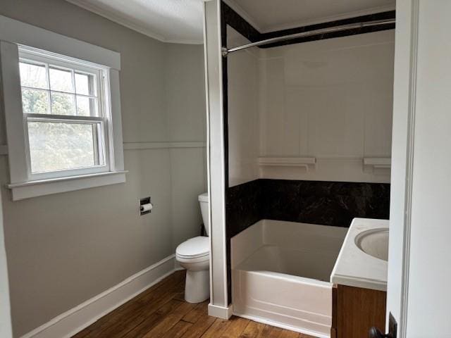 full bath featuring crown molding, baseboards, toilet, wood finished floors, and vanity