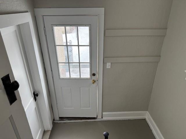 doorway to outside with baseboards