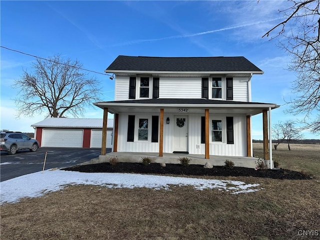 view of front of house with a garage, an outbuilding, and covered porch