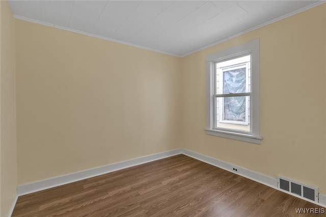 spare room featuring wood-type flooring and ornamental molding