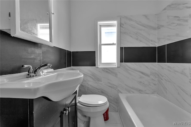 bathroom featuring a tub to relax in, toilet, tile walls, and vanity