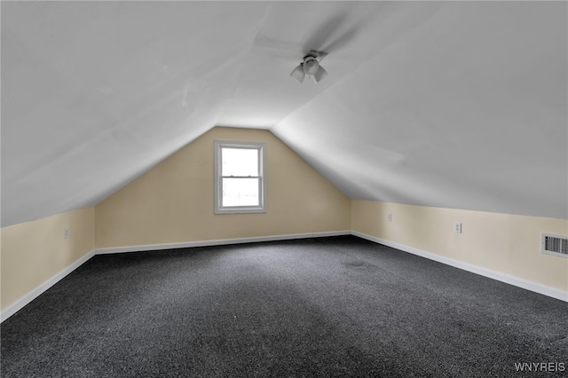 bonus room with vaulted ceiling and carpet flooring