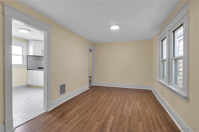 spare room featuring hardwood / wood-style floors and a wealth of natural light