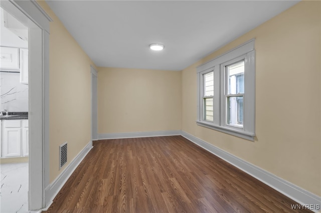 spare room with dark hardwood / wood-style floors and sink