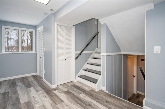 stairs featuring vaulted ceiling and hardwood / wood-style floors