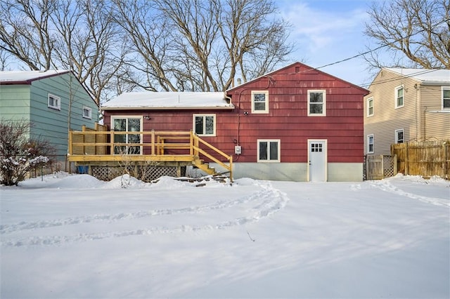 snow covered rear of property featuring a wooden deck