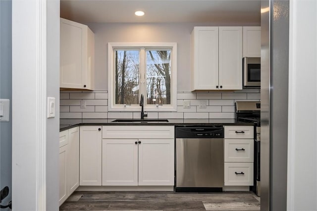 kitchen featuring appliances with stainless steel finishes, sink, white cabinets, and dark hardwood / wood-style floors