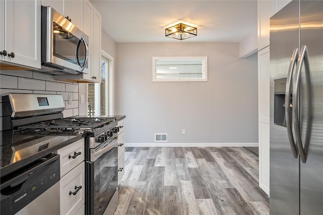 kitchen featuring white cabinetry, appliances with stainless steel finishes, tasteful backsplash, and light hardwood / wood-style flooring