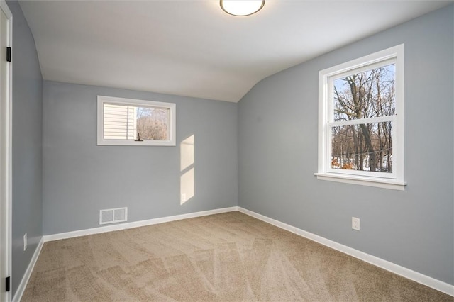 spare room featuring vaulted ceiling and carpet