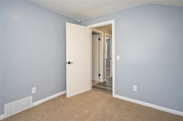 carpeted empty room with lofted ceiling