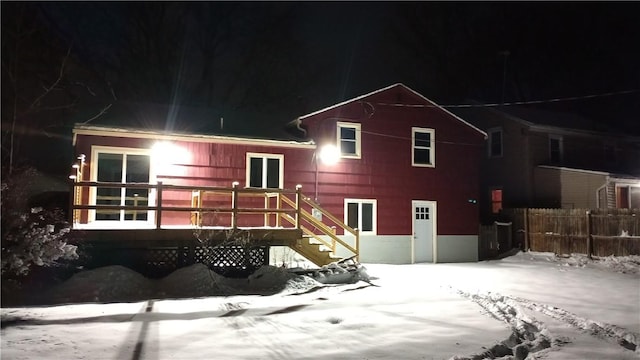 snow covered house featuring a deck