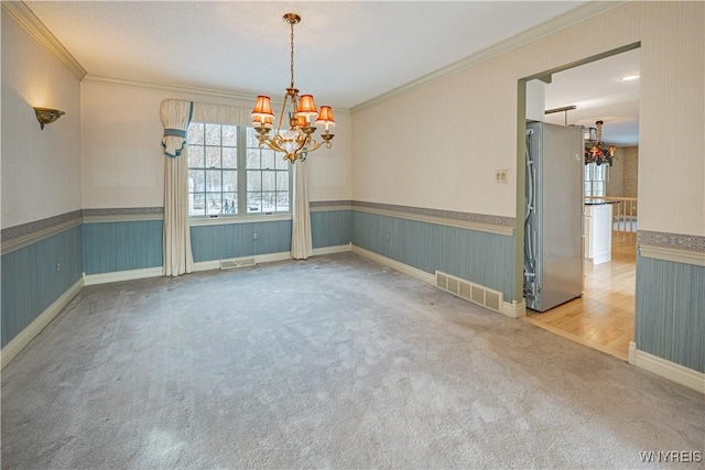 empty room featuring ornamental molding, a chandelier, and carpet