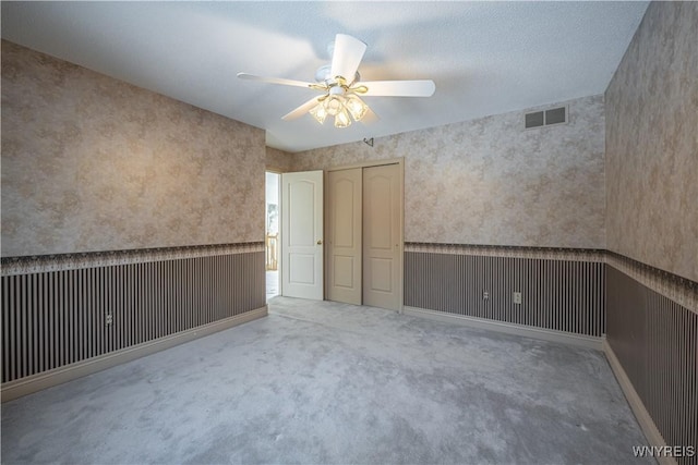 empty room with ceiling fan and carpet