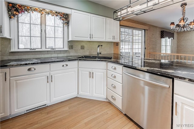 kitchen with sink, stainless steel dishwasher, white cabinets, and dark stone counters